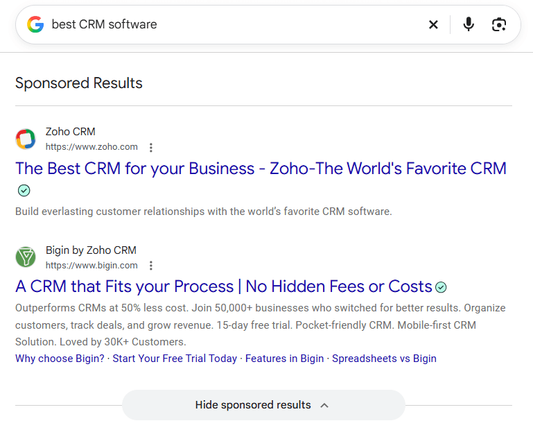 Google search results for best CRM software showing sponsored listings from Zoho CRM and Bigin by Zoho CRM